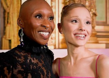 Dos mujeres sonrientes en un estreno en París con un impresionante look de la vieja Hollywood, una con vestido negro de encaje y la otra con un vestido rosa con tirantes finos