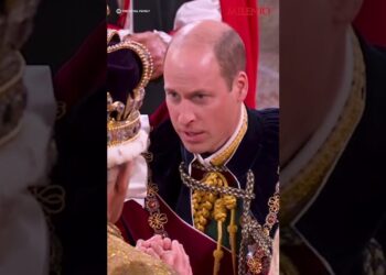 Hombre arrodillado frente a una figura con corona mostrando una reacción emotiva durante una ceremonia oficial