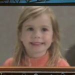 Niña rubia sonriente proyectada en una pantalla gigante dentro de una sala, Qué fue de MacGyver: la vida actual de Richard Dean Anderson