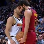 Enfrentamiento frontal entre dos jugadores de baloncesto en plena cancha, balón en mano y público tenso, ¿Cuánto cobra Ricky Rubio? Descubre su salario y secretos financieros