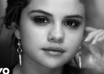 Mujer joven en primer plano en blanco y negro con pendientes largos y mirada serena, retrato elegante.