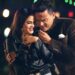 Patrimonio de Silvestre Dangond: Descubre su fortuna y éxito 19 Pareja abrazada en una escena nocturna con luces festivas, Patrimonio de Silvestre Dangond: Descubre su fortuna y éxito