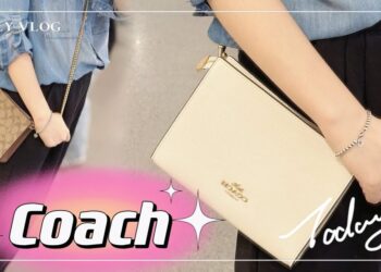Mujer sostiene dos bolsos Coach crossbody, uno crema con cadena dorada y otro de monograma marrón; Descubre por qué esta bolsa de Coach de $250 ahora cuesta solo $75 y todos la consideran ‘perfecta’.