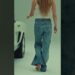 Descubre cómo Sydney Sweeney deslumbró con sus piernas en su nueva campaña de moda 11 Mujer de espaldas en estudio caminando descalza con jeans acampanados y top blanco junto a un automóvil, enfoque en piernas y estética de campaña de moda