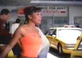 Mujer sonriente con top naranja junto a taxis en una calle urbana, ¿Qué fue de Ashley Banks? La vida actual de Tatyana Ali tras Bel-Air