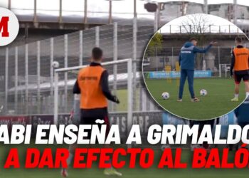 Entrenamiento de fútbol en campo con entrenador dando instrucciones a jugadores y balones cerca de la portería; La familia de Xabi Alonso: amor, hijos y momentos inolvidables