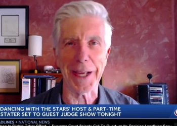 Hombre mayor en videollamada durante una cobertura de noticias sobre la fiesta del 20 aniversario de DWTS con logo de canal y cinta informativa