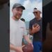 Dos hombres sonrientes en la cubierta de un barco sosteniendo balones de fútbol americano en una escena relajada; ¿Cuánto cobra Tom Brady? Descubre su impresionante fortuna y más