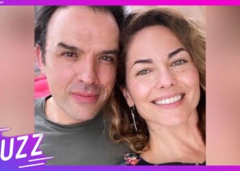 Pareja sonriente en primer plano posando para una selfie con marco morado y logo BUZZ