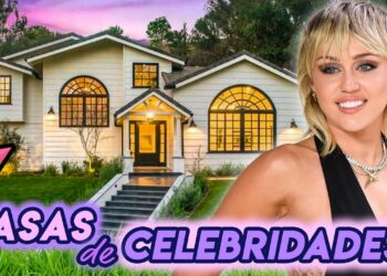 Mansión lujosa en Los Ángeles con fachada blanca, grandes ventanales arqueados, escalera de entrada y una mujer posando en primer plano