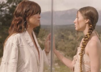 Dos mujeres frente a frente separadas por un panel de vidrio en un paisaje natural; ¿De dónde es Vanesa Martín? Descubre su origen y su historia