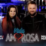 Cuatro artistas sonrientes posan frente a un letrero luminoso con corazón y el texto Vida Amorosa; Las parejas de Madonna: secretos y romances de la reina del pop