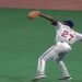 Jugador de béisbol lanzando en el jardín con el número 27 en la camiseta