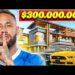 Patrimonio de Neymar: descubre su fortuna y estilo de vida lujoso 27 Persona haciendo un gesto de silencio frente a una mansión moderna y varios autos deportivos con un letrero de $300.000.000.