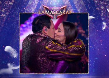 Dos personas besándose en el escenario del programa La Máscara con vestuario brillante y micrófonos de diadema