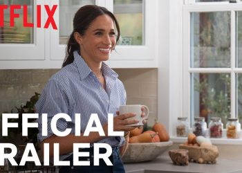 Mujer sonriente sostiene una taza en una cocina luminosa con el logo de Netflix y el texto OFFICIAL TRAILER, anuncio navideño sorpresa