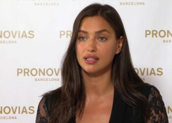 Mujer modelo posando frente al logotipo de Pronovias Barcelona, rostro sereno y cabello castaño largo