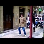 Sueldo de Àngels Barceló: ¿Cuánto gana la reina de la radio? Viandante posa frente a una banda de música de época que desfila por una calle urbana.