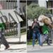 Operario trasladando una mesa y una alfombra enrollada en plena mudanza frente a un edificio residencial mientras una mujer toma fotos con su móvil
