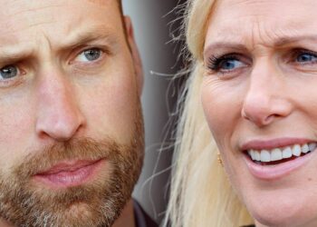 Primer plano de dos personas, una mujer rubia y un hombre con barba, con expresiones intensas y miradas dirigidas fuera de cámara.