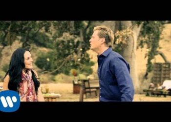 Dos personas conversando en un jardín con árboles y mobiliario rústico; ¿De dónde es Zuria Vega? Descubre su origen y trayectoria artística